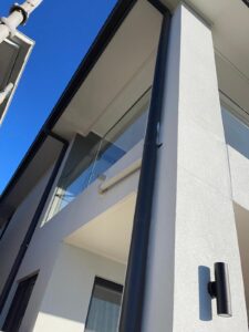 Construction site showing exposed piping running along foundation wall