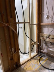 Commercial plumbing rough-in with visible pipes and wall studs