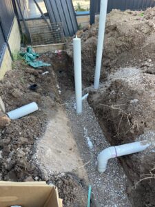 Ground excavation showing newly fitted PVC drainage pipes